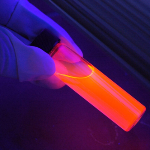 A scientist holding a glowing sample container
